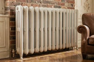 Radiateur en fonte ancien avec sections ornementales dans un appartement rénové aux murs en briques apparentes